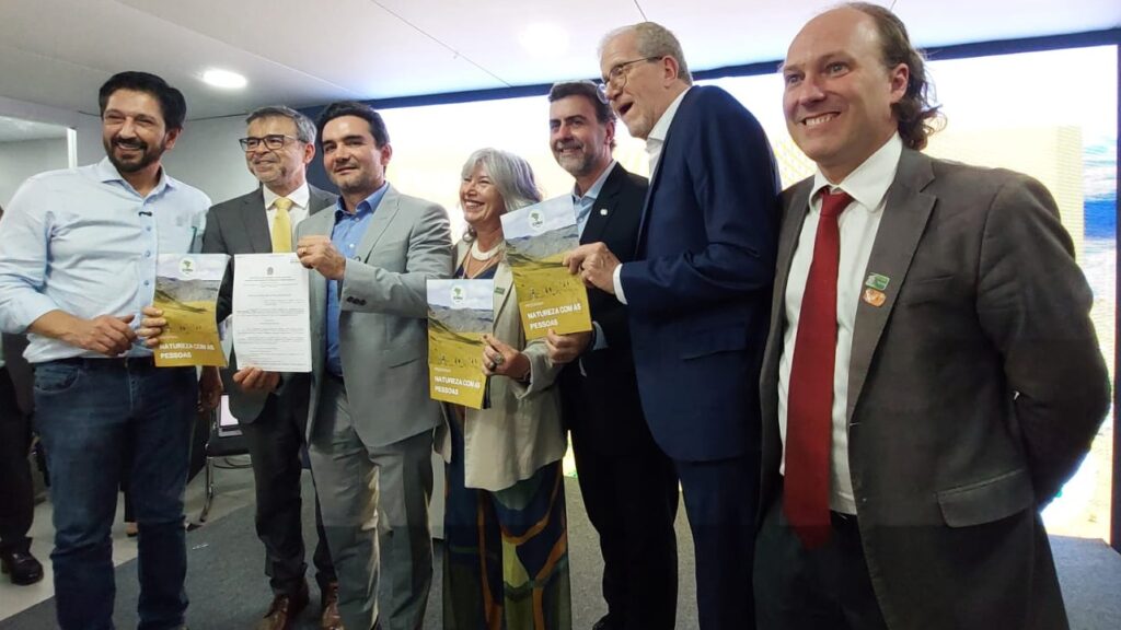Autoridades posam com publicação que traz detalhes do Programa Natureza com as Pessoas